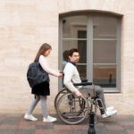 Girl helping disabled man traveling in the city